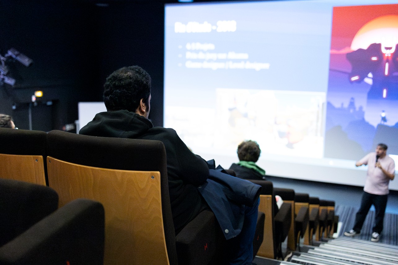 Conférence avec projection dans un amphithéâtre devant des étudiants.