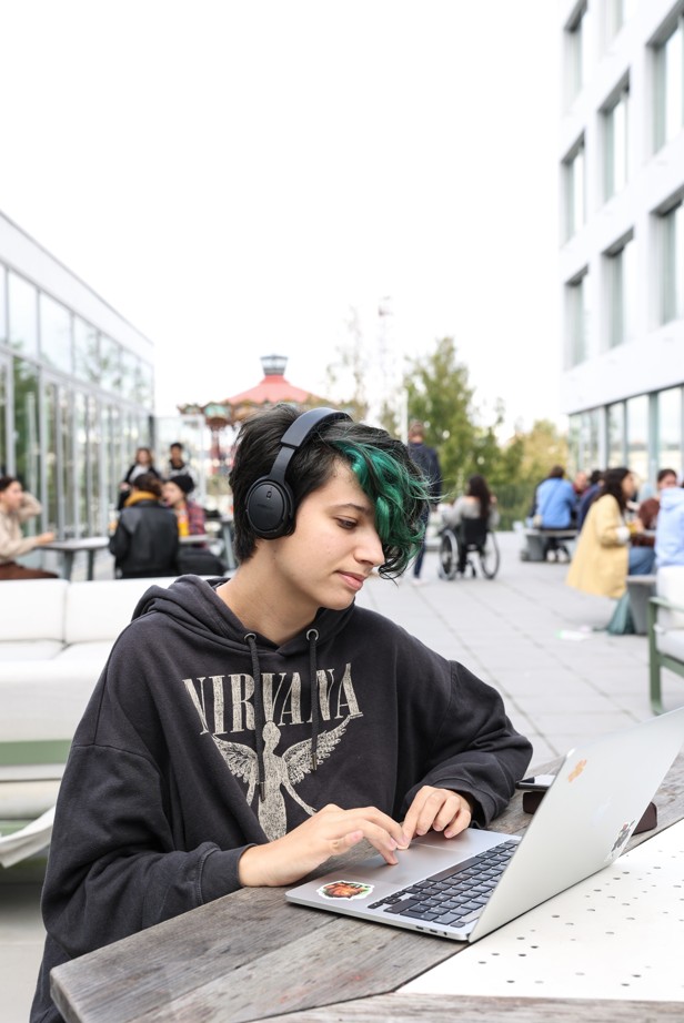 Étudiant de l’ESMA 3D Nantes travaillant sur ordinateur portable en extérieur sur le campus